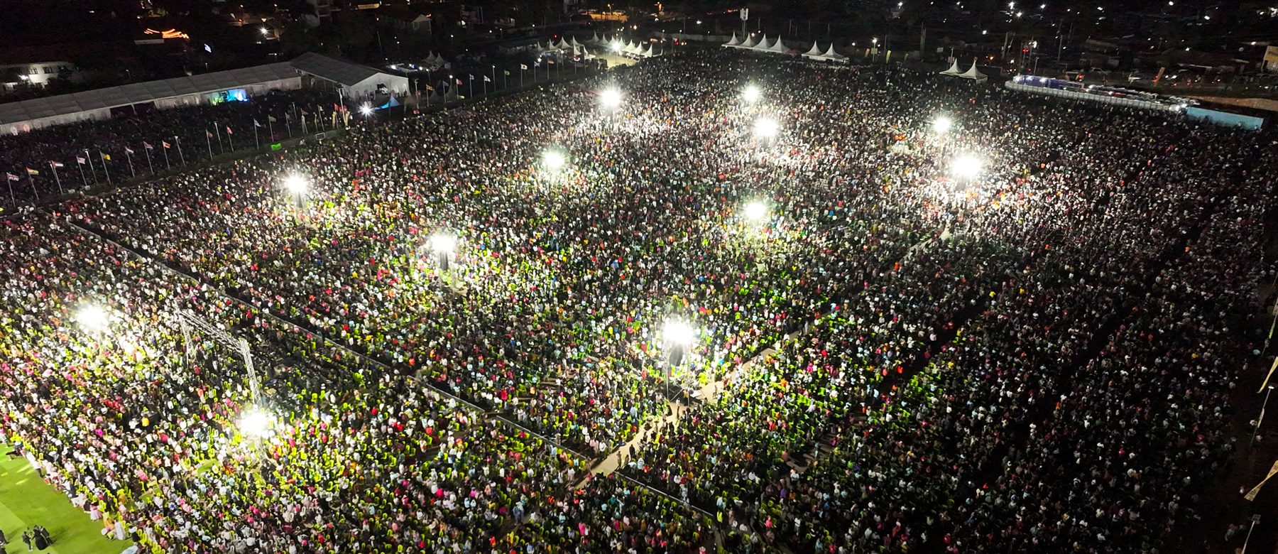 Aerial view of a packed Phaneroo gathering in Kampala at night